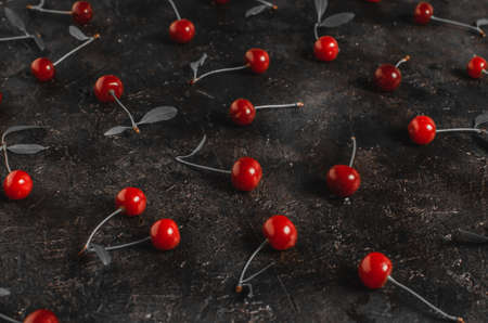 Cherry berries with leaves on the old, rustic concrete floor.