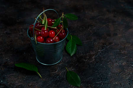 Cherry berry in a small decorative bucket on the old village,concrete floor.の写真素材