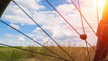 Landscape with the bright sun can be seen through the Bicycle wheel.Cycling, travel and recreation.の写真素材