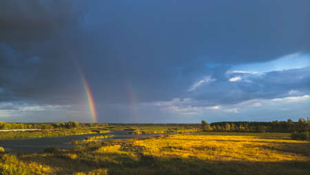 Rainbow after rain on the background of storm clouds.