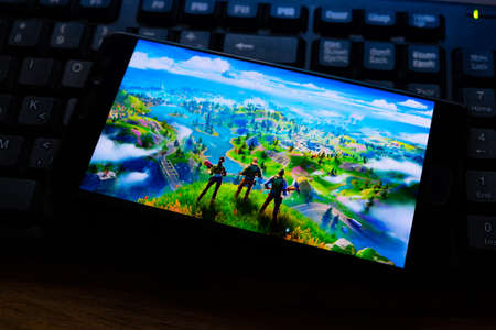 Kostanay, Kazakhstan, October 15, 2019.Mobile phone on the background of the keyboard, with the logo of the popular game fortnite 2, from Epic Games.のeditorial素材