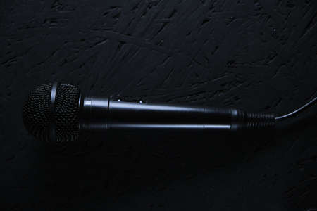 Black microphone dropped to the black wooden floor.Musical instrument for singing and karaoke.の写真素材
