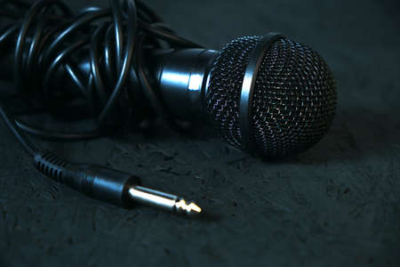 Black microphone dropped to the black wooden floor.Musical instrument for singing and karaoke.の写真素材