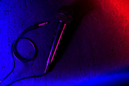 Microphone,lying on the floor, is lit with neon colors in the style of cyberpunk.の写真素材