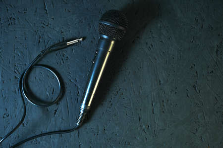 Black microphone dropped to the black wooden floor.Musical instrument for singing and karaoke.の写真素材