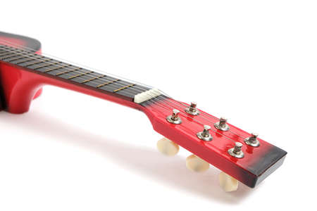 Red guitar with string tensioners on a white background close-up.の写真素材