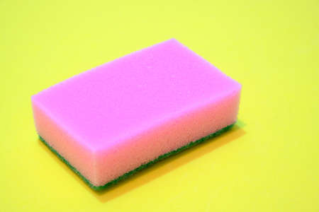 Pink sponge for washing dishes on a yellow backgroundの写真素材