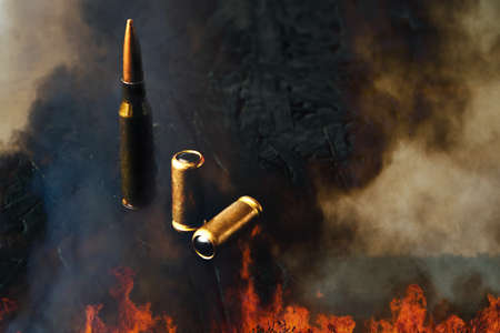Bullets from firearms against a background of black smoke and flames