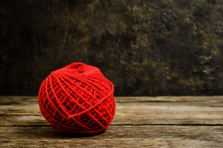 Red ball of wool yarn against an old wallの写真素材