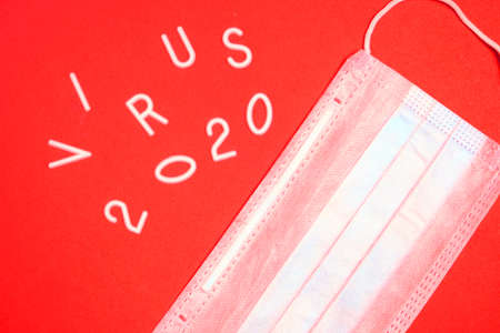 Medical mask for protection and the inscription virus 2020 on a red backgroundの写真素材