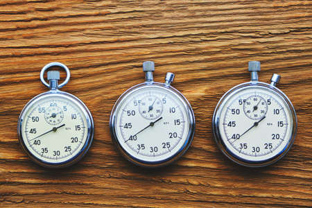 Three retro mechanical stopwatches on a wooden backgroundの写真素材