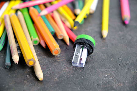 Old colored pencils and a broken pencil sharpener on the floor