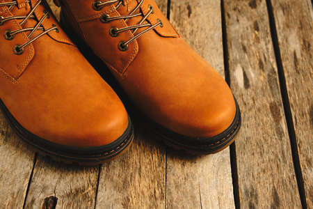 Brown, laced autumn boots on an old wooden, rustic backgroundの写真素材