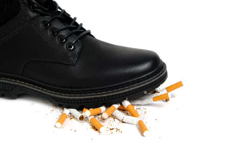 Black Shoe crushes cigarettes on a white background.Refusal of smokingの写真素材