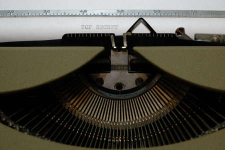 Old retro vintage typewriter. A white sheet with the printed text top secret