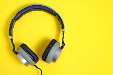 Wired headphones in khaki on a yellow backgroundの写真素材