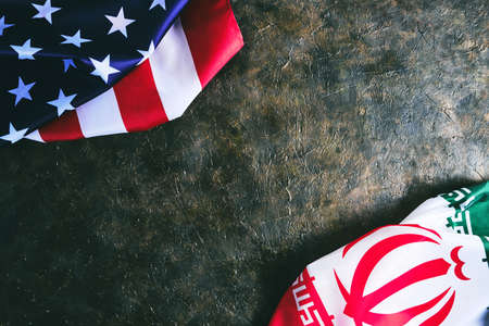 Flags of Iran and United States of America are opposite each other dark backgroundの写真素材