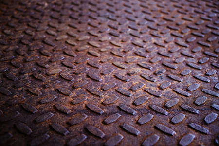 Old and rusty metal floor. Texture of a rough metal sheet with a convex pattern