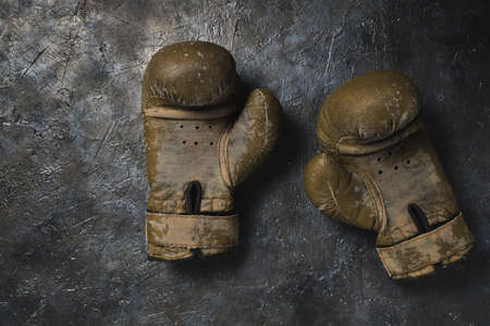 Old brown Boxing gloves on a concrete background