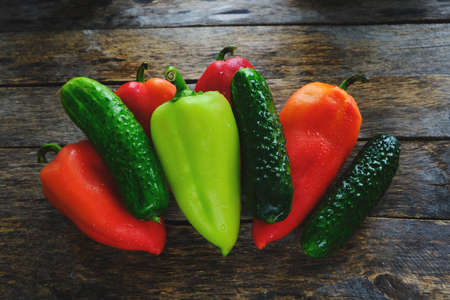 Bell peppers and cucumbers on an old wooden backgroundの写真素材