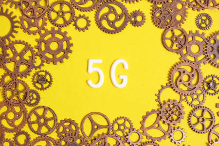 Modern communication technologies 5G logo on a yellow background among the gears