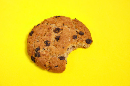 Chocolate chip cookies with chocolate chips on a yellow backgroundの写真素材