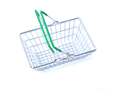 Metal shopping basket with green handles on white backgroundの写真素材