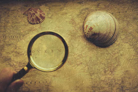 Ocean territory on an old map under a magnifying glass, seashellsの写真素材