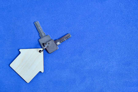 House Keys Keychain on Blue Background Concept Buy Rent Loan Apartment or House