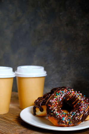 Chocolate donuts and takeaway coffee on a dark backgroundの写真素材