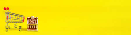 Banner, concept of buying house or apartment, shopping basket and house, on yellow background