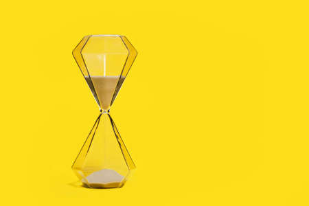 Hourglass on a yellow background, passing timeの写真素材
