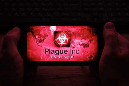 Kostanay, Kazakhstan, November 01, 2021. In hand is mobile phone with a screensaver of popular game Plague Incのeditorial素材