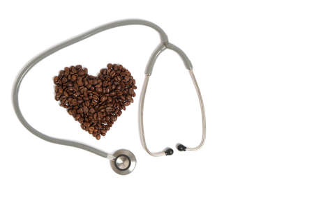 Stethoscope and coffee beans in form heart on white background.Concept heart disease and addictionの写真素材