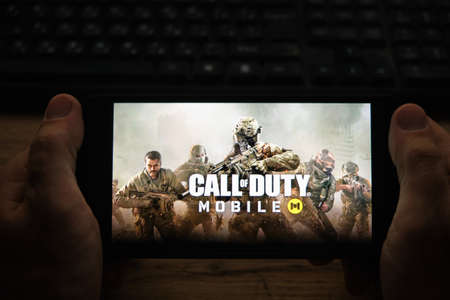 Kostanay, Kazakhstan, November 04, 2021. A man holds a mobile phone with a screensaver of the popular Call of Duty gameのeditorial素材