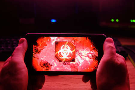 Kostanay, Kazakhstan, November 01, 2021. In hand is mobile phone with a screensaver of popular game Plague Incのeditorial素材