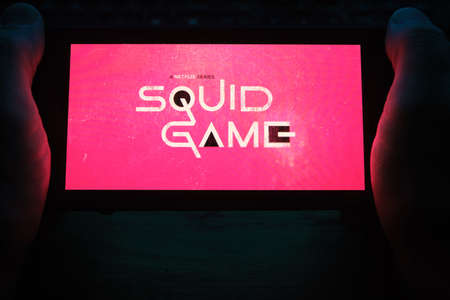 Kostanay, Kazakhstan, November 17, 2021. Logo of the series Squid Game from NETFLIX is an American entertainment company, a streaming service for movies and TV series on a smartphone screenのeditorial素材
