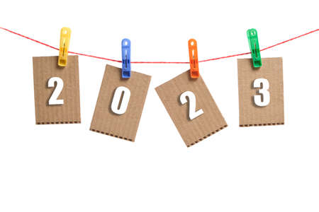 Figures for 2023 are hung on cardboard cards, hung on clothespins on a white background