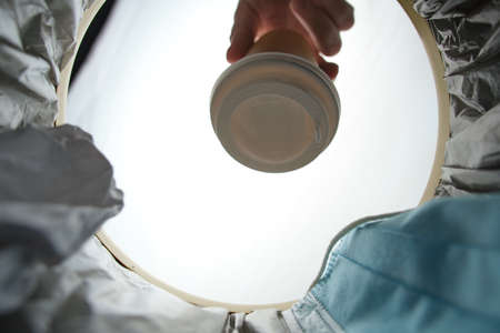 Disposable coffee cup is thrown into the trash.View from inside bucket