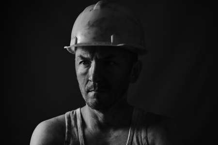 Portrait miner in helmet and undershirt with dirty faceの写真素材