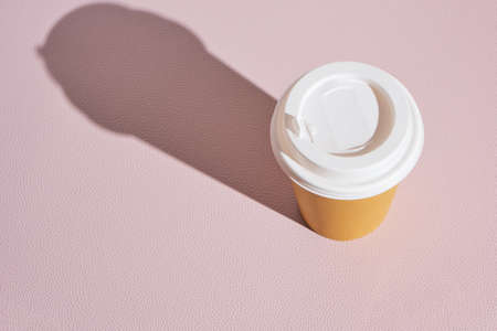 Paper disposable cup for hot coffee and tea on pink background.Concept and trend of takeaway food