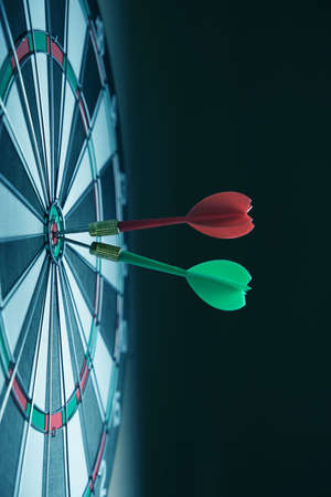 Dartboard with darts stuck right in center of the target