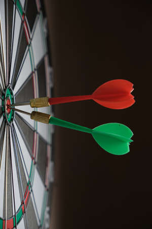 Dartboard with darts stuck right in center of the targetの写真素材