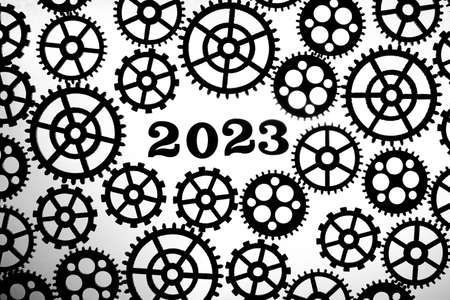 2023 on a background with silhouettes of gears on a white background.