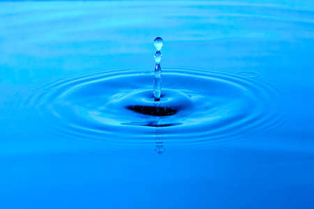 Splash water after drop falls.Blue abstract background with drop in water