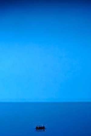 Water splashes after raindrop falls.Blue abstract background with splash of drop of waterの写真素材