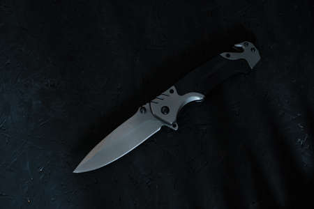 Tactical folding knife for survival and active lifestyle and recreation, on a dark backgroundの写真素材