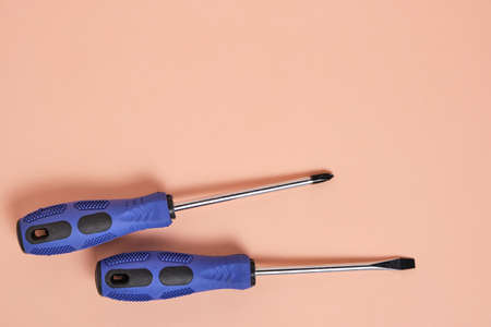 Two blue screwdrivers on pastel beige background.Concept of womens gift for spring holiday on eighth Marchの写真素材