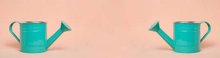 Banner two green watering cans on pastel beige background.Concept beginning summer seasonの写真素材