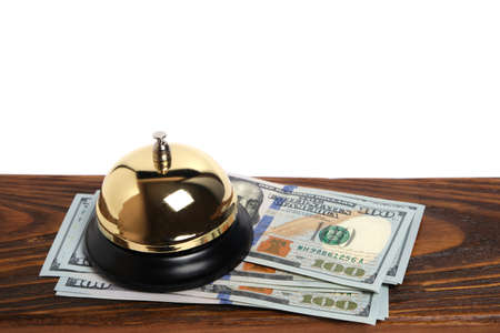 Gilded bell hotel service and hundred dollar bills on wooden reception desk hotel.Conceptual hotel,...